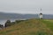 Windmill and Icelandic flag in Vigur island in a cloudy and windy day, Iceland