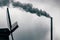 Windmill and industrial chimney in a dark and cloudy day in Zaanse Schans The Netherlands with pollution