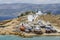A windmill with its sails on in Koufonsion Greece with winter stored boats in front
