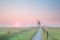 Windmill on misty Dutch farmland