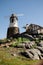 Windmill with old rock castle. red tile roof and string lights. Modern windmill. Country side on a bright summer day