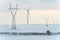 Windmill and powerlines on the field in winter