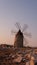 Windmill on the shore seaside with sunset in the background. North of Sicily, Trapani, old fashioned windmill on the
