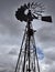 A windmill silhouetted against fluffy clouds