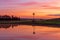 Windmill sits on farm land with beautiful sunrise sky