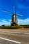 Windmill surrounded by a fence next to a road