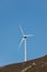 Windmill turbine silhouetted against blue sky