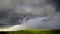 A windmill turning in the wind against storm clouds