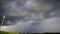 A windmill turning in the wind against storm clouds