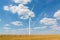 Windmill on the wheat field with hay bales