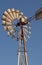 WINDMILL WHEEL AND STACK AGAINST BLUE SKY