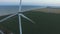 Windmills along the coast in green fields under blue skies. Aerial survey. Close up