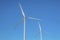 Windmills alternative energy source against clear blue sky background