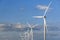 Windmills on a background of blue sky with clouds. Wind energy. Alternative energy