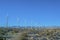 Windmills on dry rocky land against mountain and vast blue sky