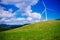 Windmills for electric power on a green hill farm and blue sky white cloud