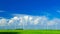 Windmills on a green field, on a bright sunny and windy day with forming cumulonimbus