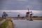 Windmills and a heavily cloudy sky in the winter, on the waterfront in Kinderdijk