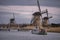 Windmills and a heavily cloudy sky in the winter, on the waterfront in Kinderdijk