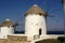 Windmills looking over the Aegean Sea with stark contrast from the white-washed and the deep blue sea.