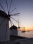 Windmills at Mykonos at sunset at sea and the ship