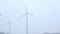 Windmills near the road foggy morning.