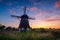 Windmills in the Netherlands. Historic buildings. Agriculture. Summer landscape during sunset. Bright sky and the silhouette of a