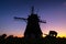 Windmills in the Netherlands. Historic buildings. Agriculture. Summer landscape during sunset. Bright sky and the silhouette of a