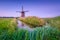 Windmills in the Netherlands. Historic buildings. Agriculture. Summer landscape during sunset. Bright sky and windmill.