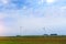 Windmills rotate blades over farmland