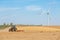 Windmills and tractor on the field with storks