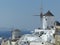 Windmills in a traditional white village to Santorini in Greece.