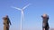 Windmills turning, happy girlfriends enthusiastically pointing at wind turbine