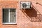 Window and air conditioner on a brick wall