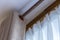 Window beige curtains and white tulle on the curtain rod