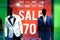 Window of Boutique With Two Black Mannequins in Business Suites With Sign Advertising Sale 70