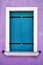 Window with bright blue shutters on lilac wall. Italy, Venice, Burano