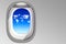 Window cabin of airplane and blue sky with clouds in shape of world map concept for transportation and travel around the world