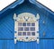 Window with carved platbands under a roof of the blue house