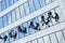 Window cleaners wash the glass facade on the same level. Industrial climbers wash the Windows of a modern skyscraper