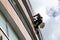 Window cleaning by climber on high-rise building.