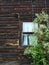 a window in a clematis-covered wooden wall