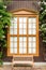 Window with curtains and shutters on a wooden house from boards with flowers and a bench