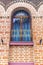 Window with decorative metal grid on stylish brick wall