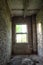 Window light illuminates an abandoned room. Abandoned brick building