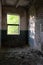 Window light illuminates an abandoned room. Abandoned brick building