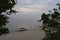 Through Window of Nature - View of Peaceful and Uncrowded White Sandy Beach from Gap between Trees