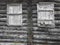 The window of the old boarded wooden log house on the background of wooden walls