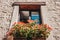 Window in a provencal style with beautiful potted flowers on the windowsill