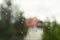 Window with rain drops with wiev on a forest and house